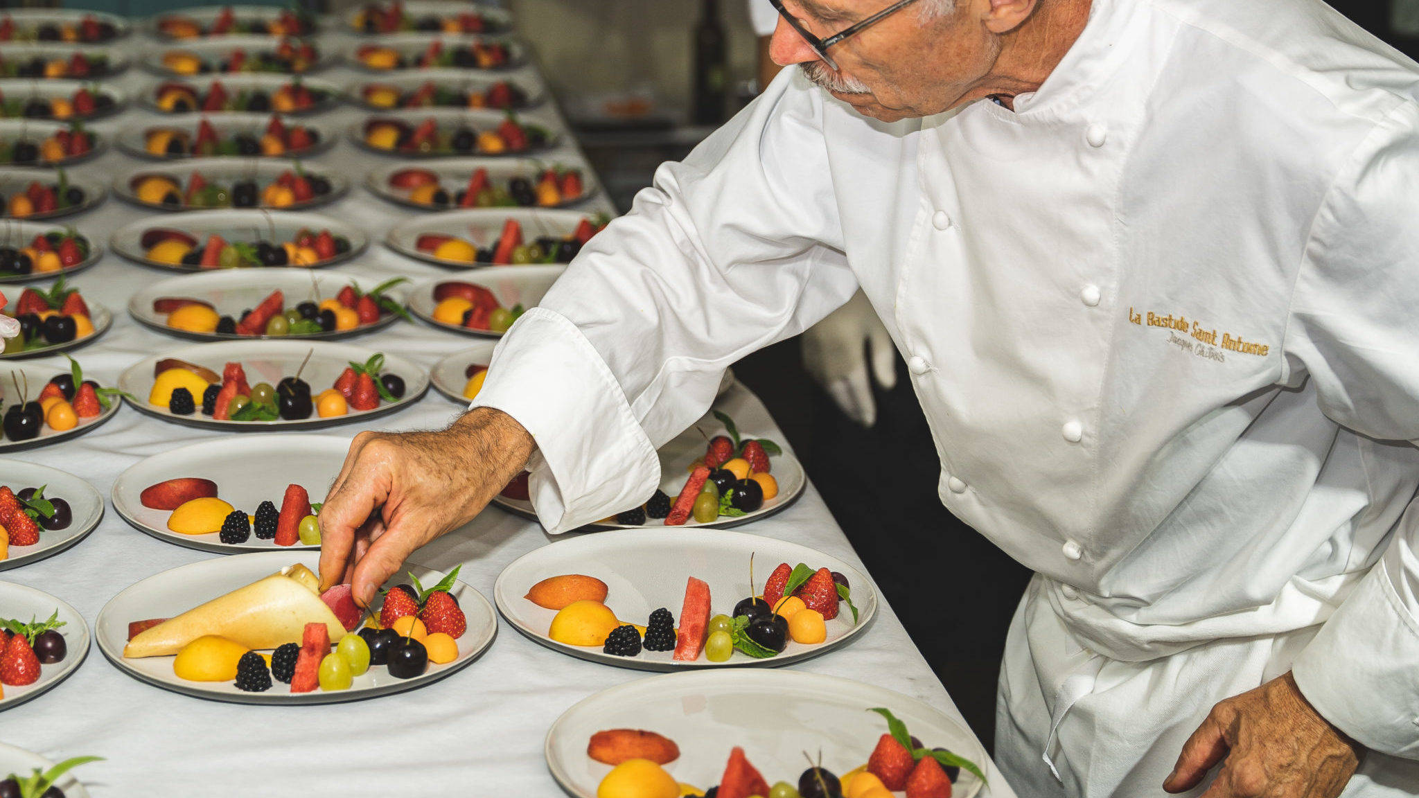 Chef Jacques Chibois, dressant les assiettes du dessert pour le dîner organisé par l'Hédonisterie